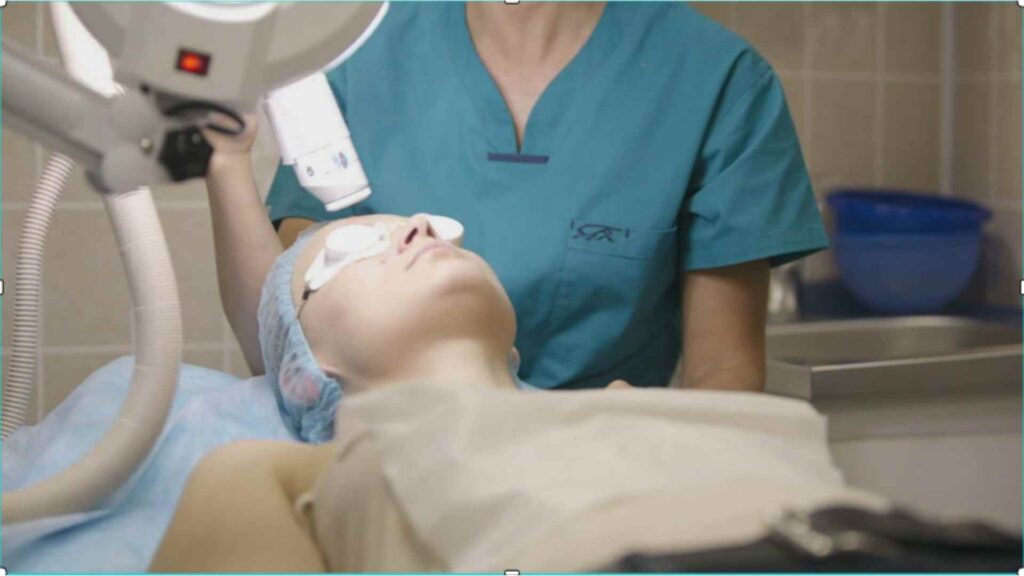 A doctor conducting laser hair removal on a female patient