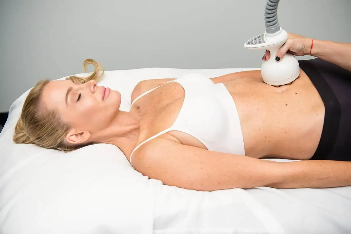 a woman lying on a bed with a device on her stomach